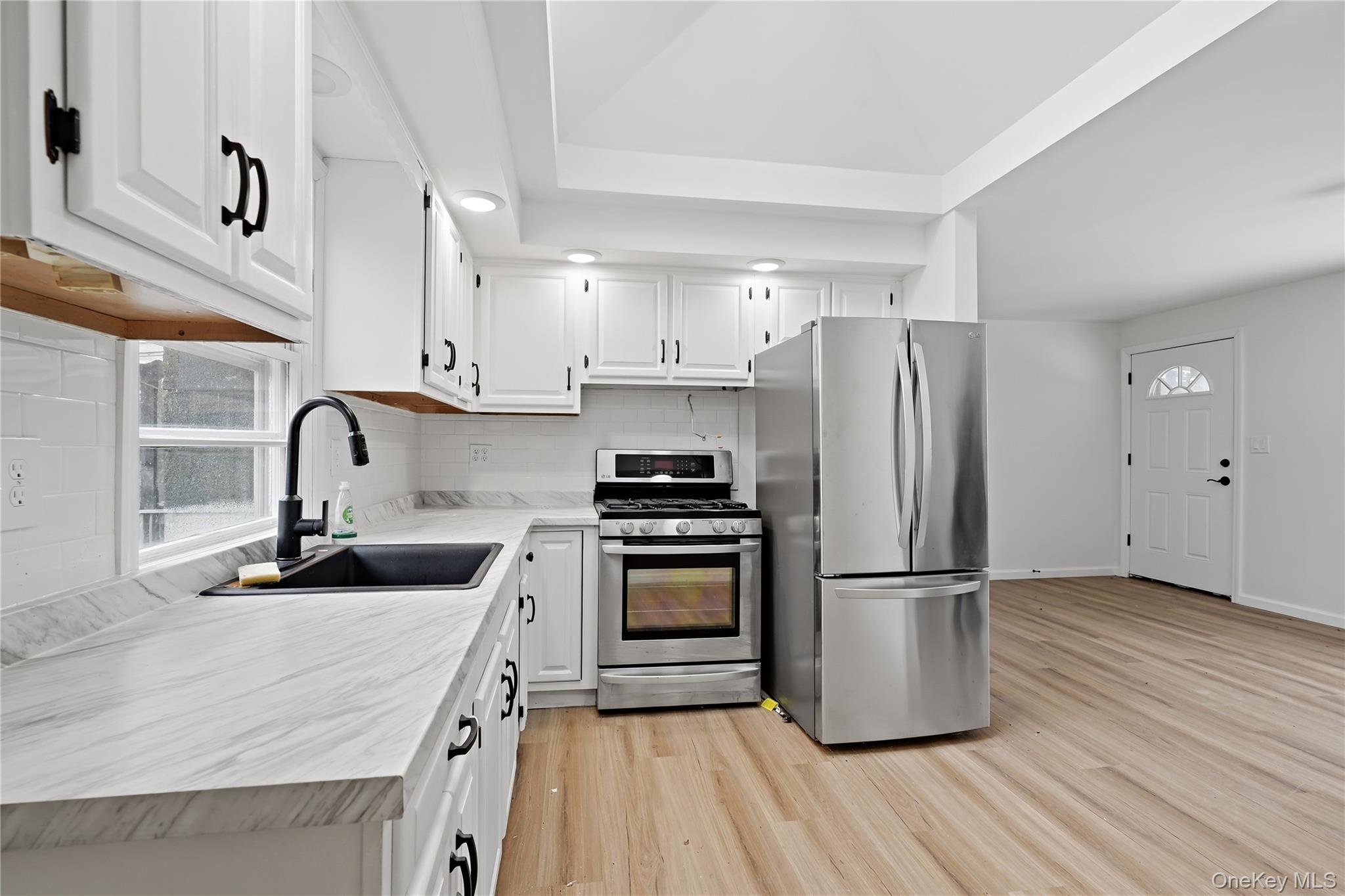 384 Tempaloni Road Ellenville, NY 12428 - Photo 7 of 18 a kitchen with wooden floor white stainless steel appliances and sink