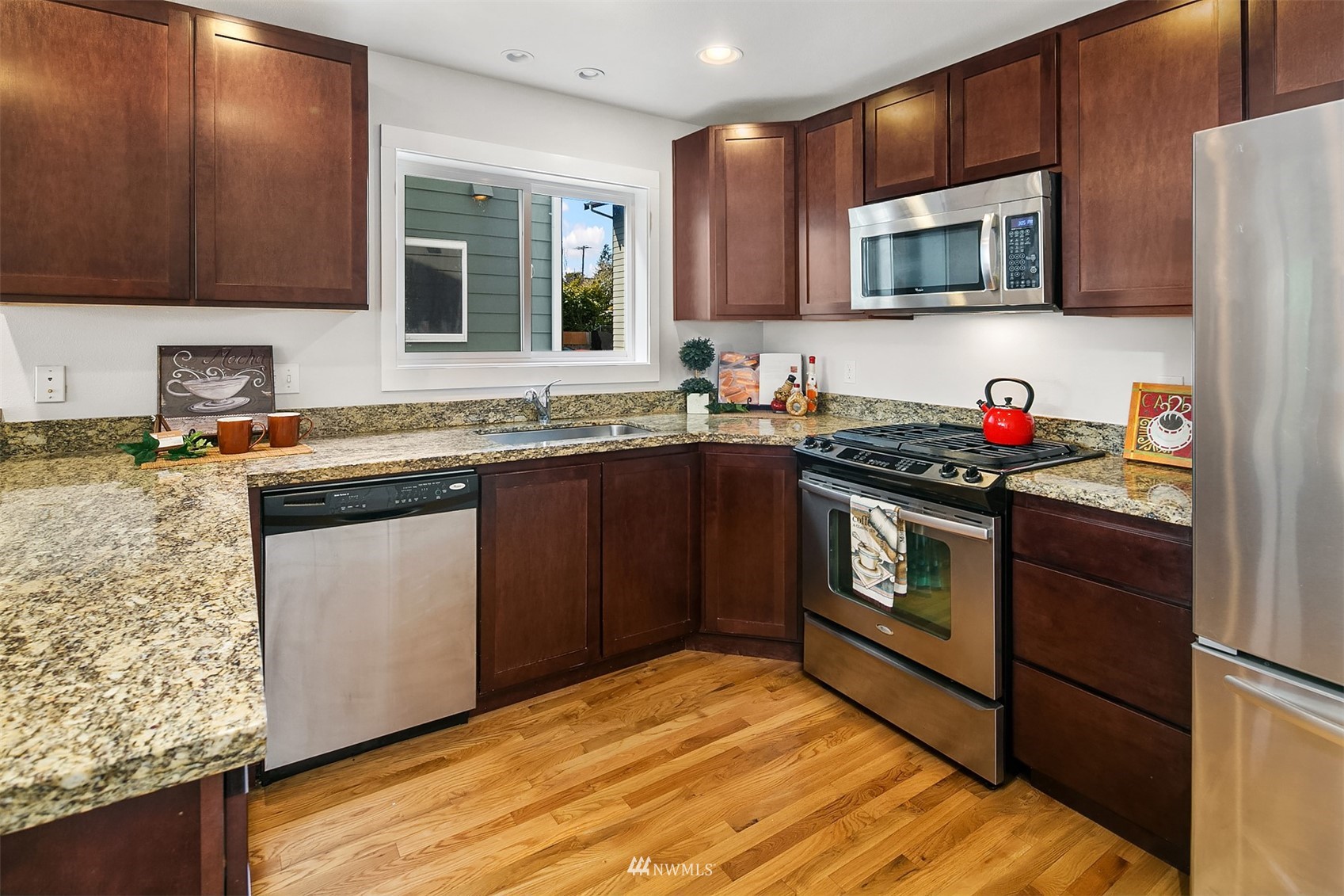 926 North 96th Street Seattle, WA 98103 - Photo 7 of 16 a kitchen with stainless steel appliances granite countertop a stove a sink dishwasher and a microwave oven with cabinets