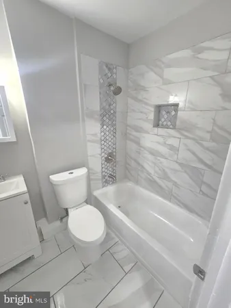 a white toilet sitting next to a bath tub and a shower
