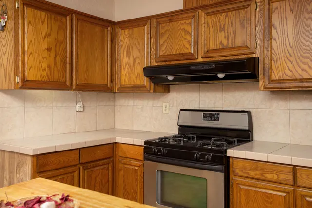 a kitchen with wooden cabinets and a stove top oven