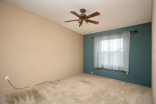 a view of a livingroom with a ceiling fan and window