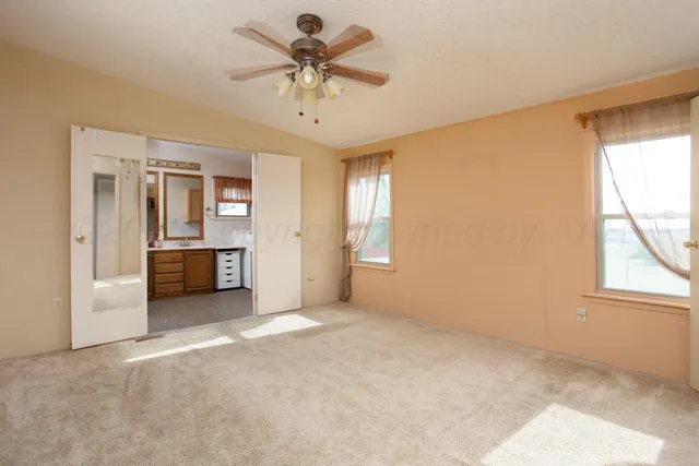 an empty room with windows and cabinet