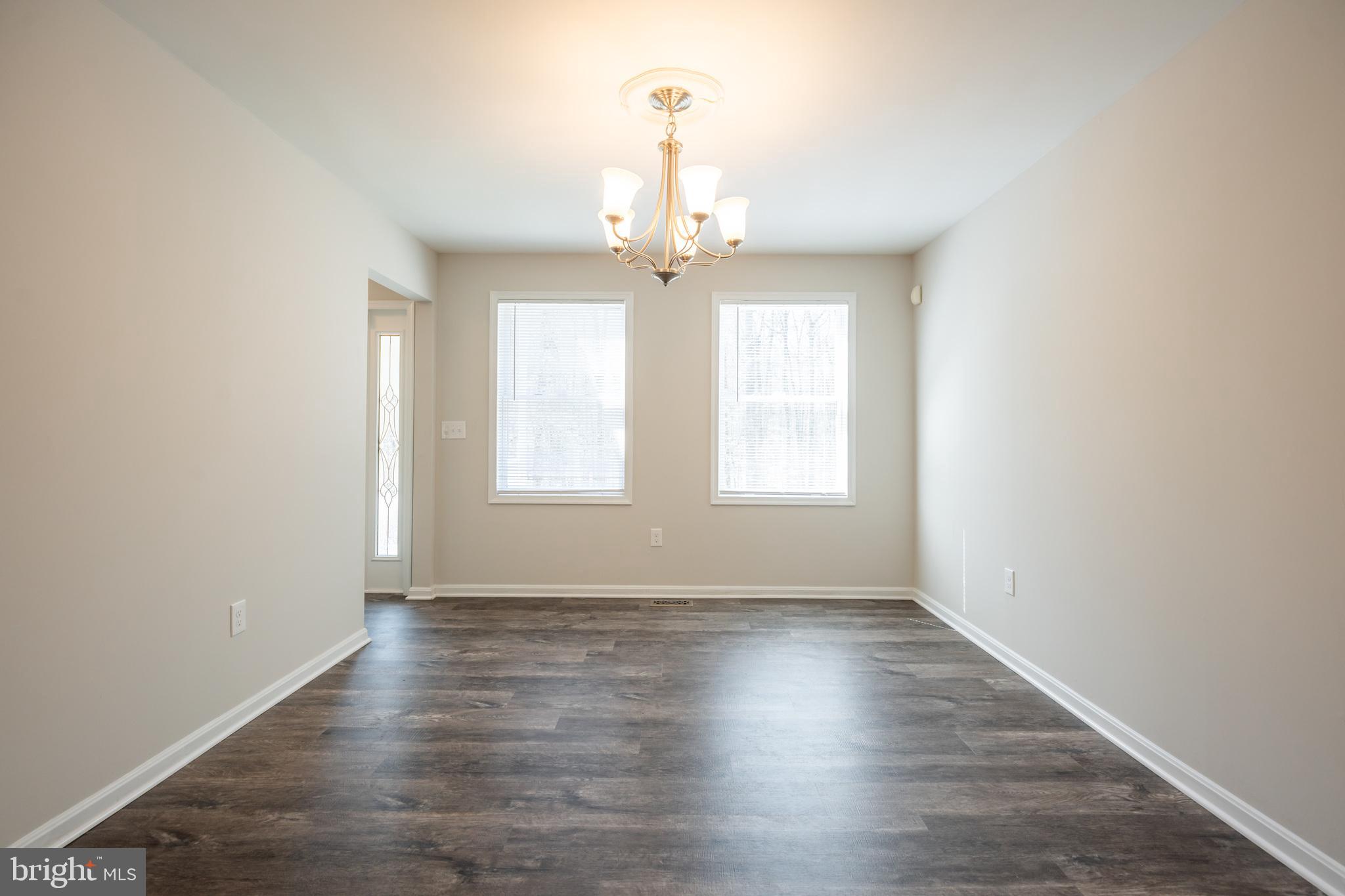 4365 Harvey Road Huntingtown, MD 20639 - Photo 11 of 36 an empty room with wooden floor chandelier and windows