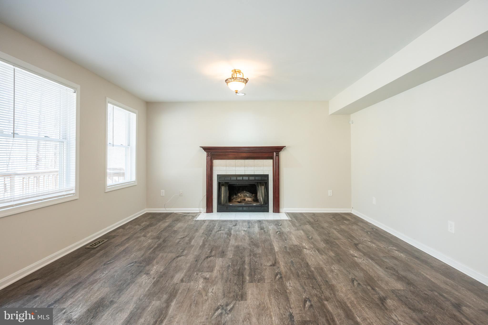 4365 Harvey Road Huntingtown, MD 20639 - Photo 13 of 36 an empty room with windows and fireplace