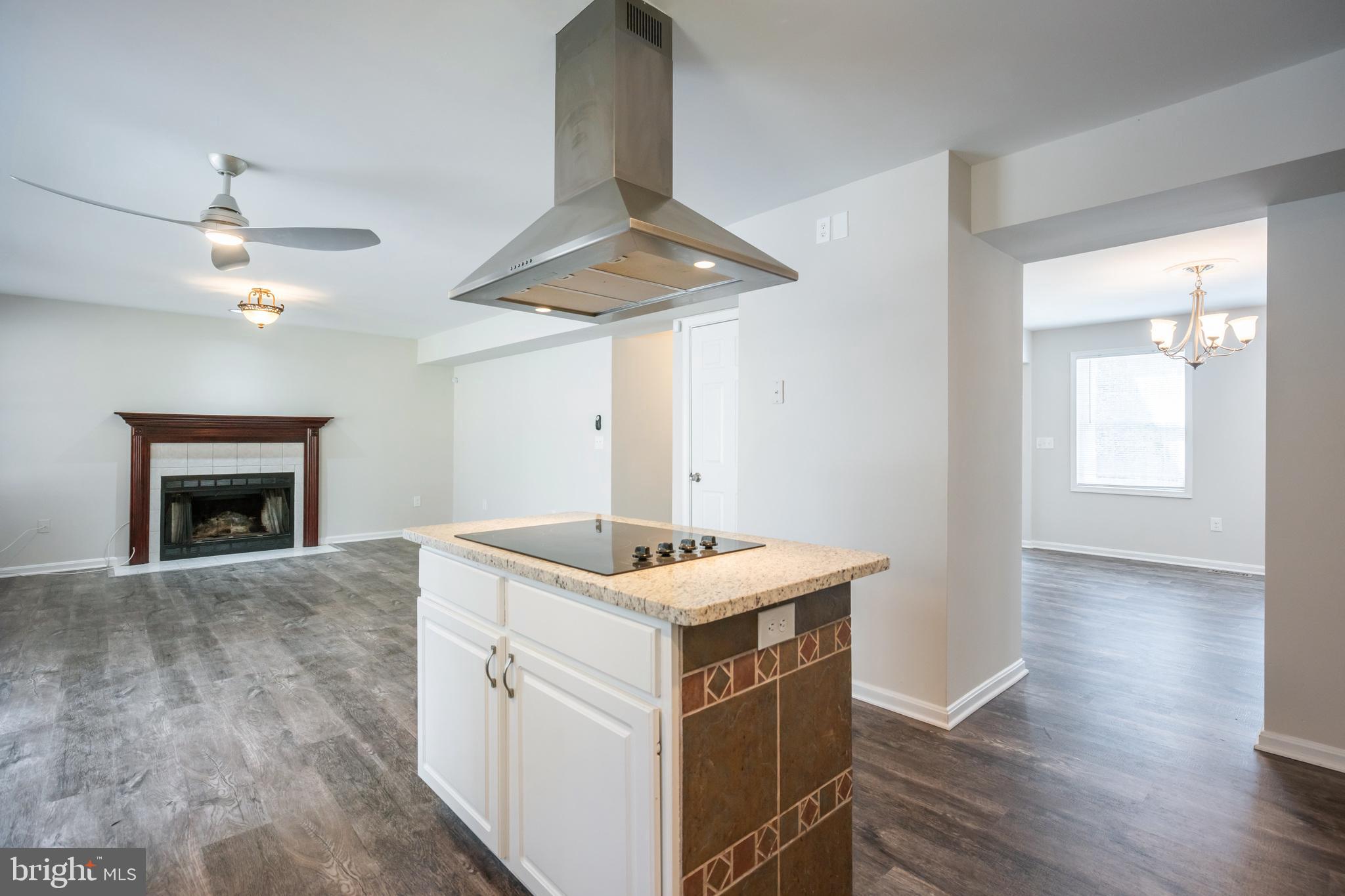 4365 Harvey Road Huntingtown, MD 20639 - Photo 18 of 36 a kitchen with a sink a chandelier and fireplace