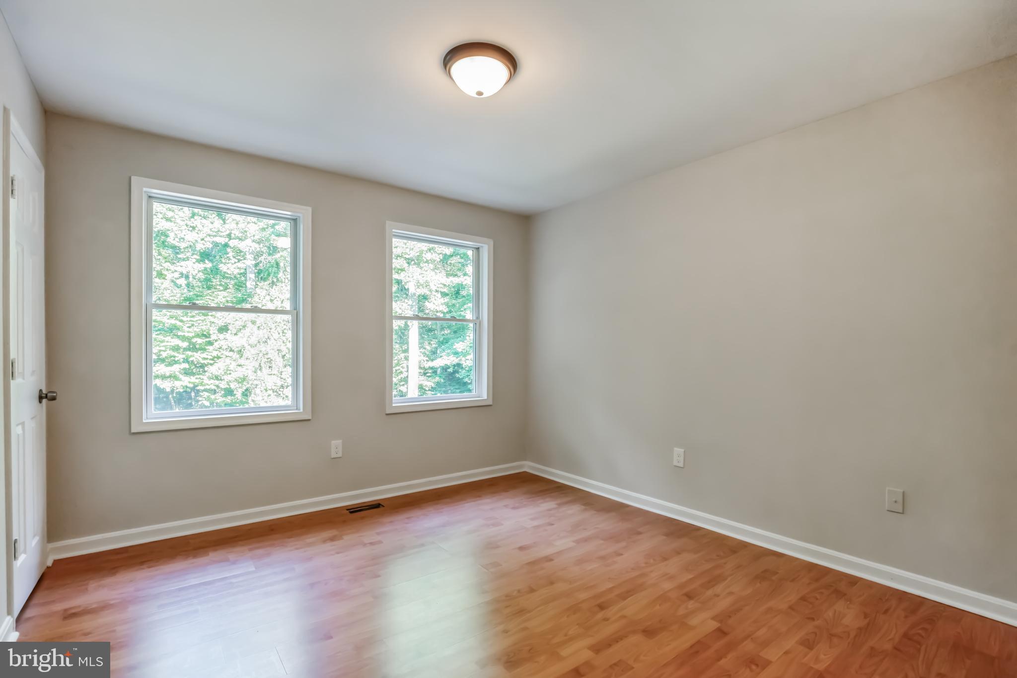 4365 Harvey Road Huntingtown, MD 20639 - Photo 20 of 36 an empty room with wooden floor and windows