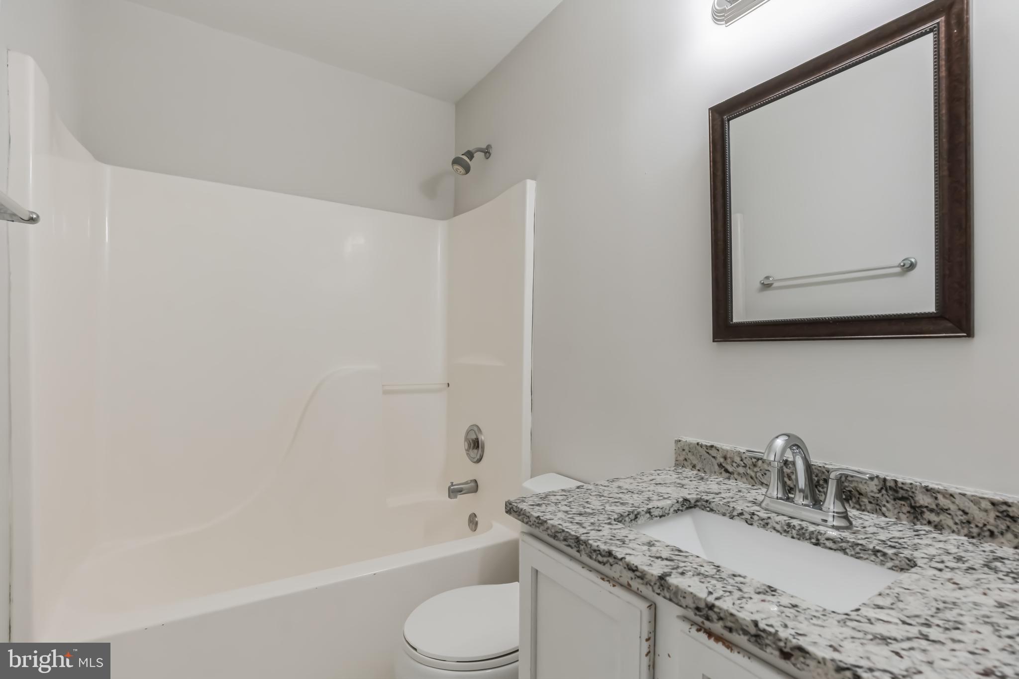 4365 Harvey Road Huntingtown, MD 20639 - Photo 23 of 36 a bathroom with a granite countertop sink toilet and shower