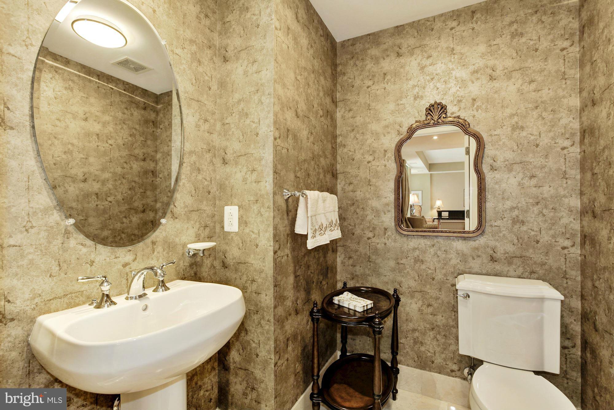 2425 L Street Northwest, Unit 412 Washington, DC 20037 - Photo 11 of 28 a bathroom with a toilet sink and mirror