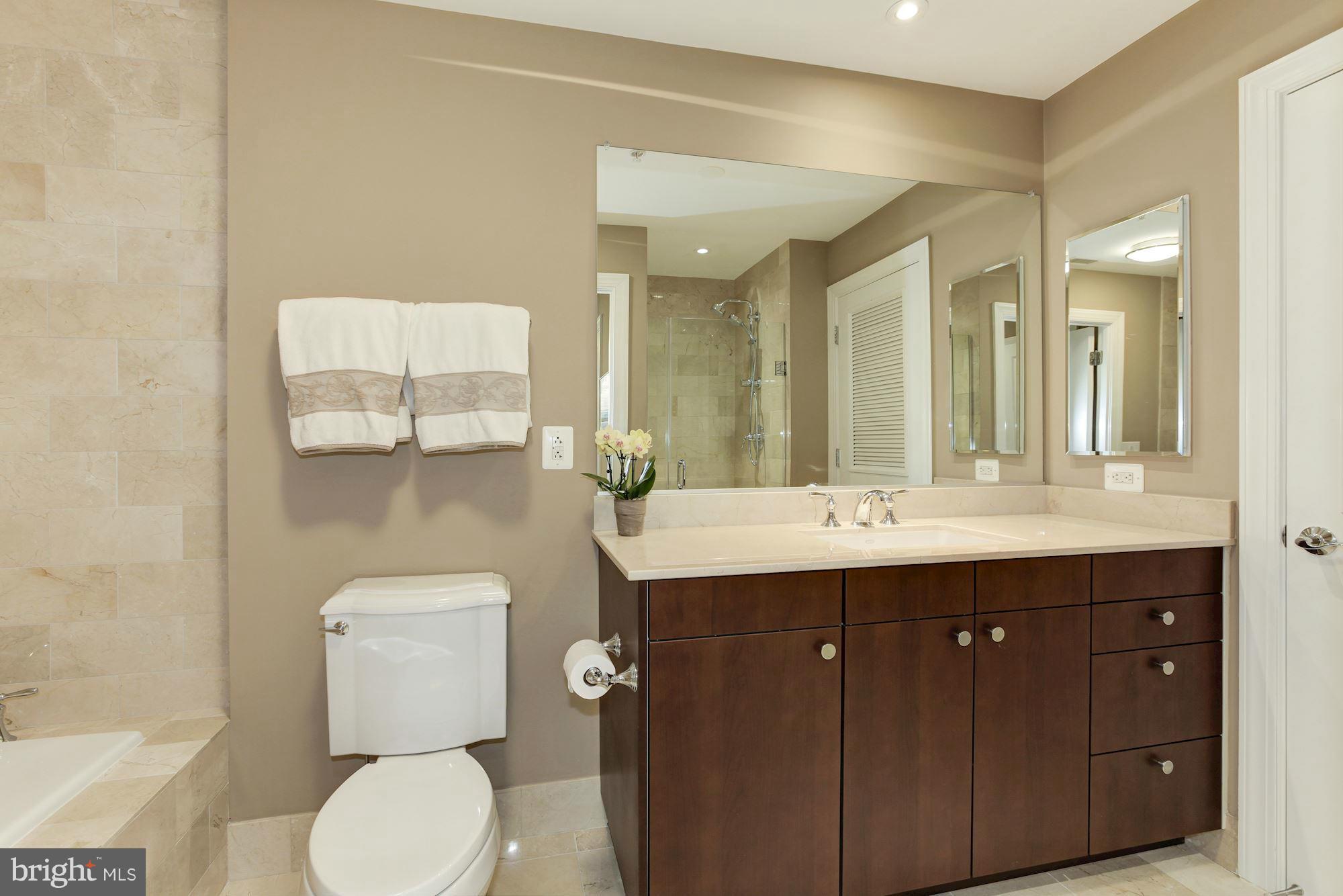 2425 L Street Northwest, Unit 412 Washington, DC 20037 - Photo 14 of 28 a bathroom with a toilet a sink and mirror