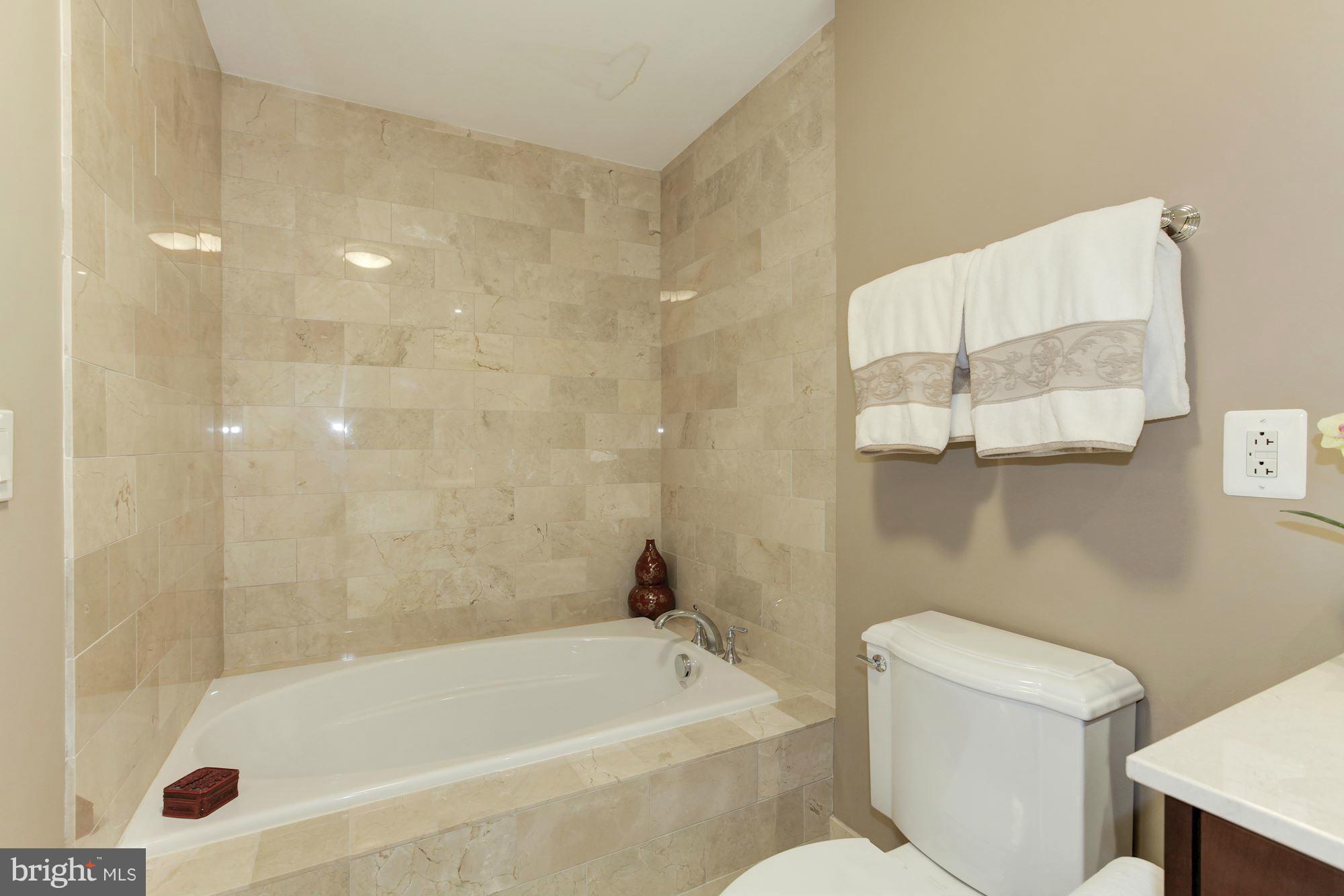 2425 L Street Northwest, Unit 412 Washington, DC 20037 - Photo 15 of 28 a bathroom with a bathtub and a toilet