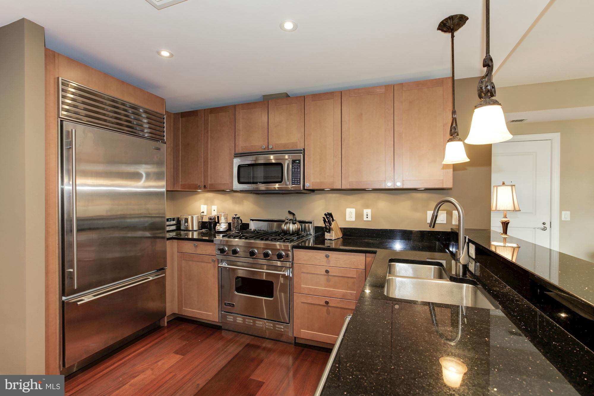 2425 L Street Northwest, Unit 412 Washington, DC 20037 - Photo 8 of 28 a kitchen with stainless steel appliances granite countertop a stove a sink and a refrigerator