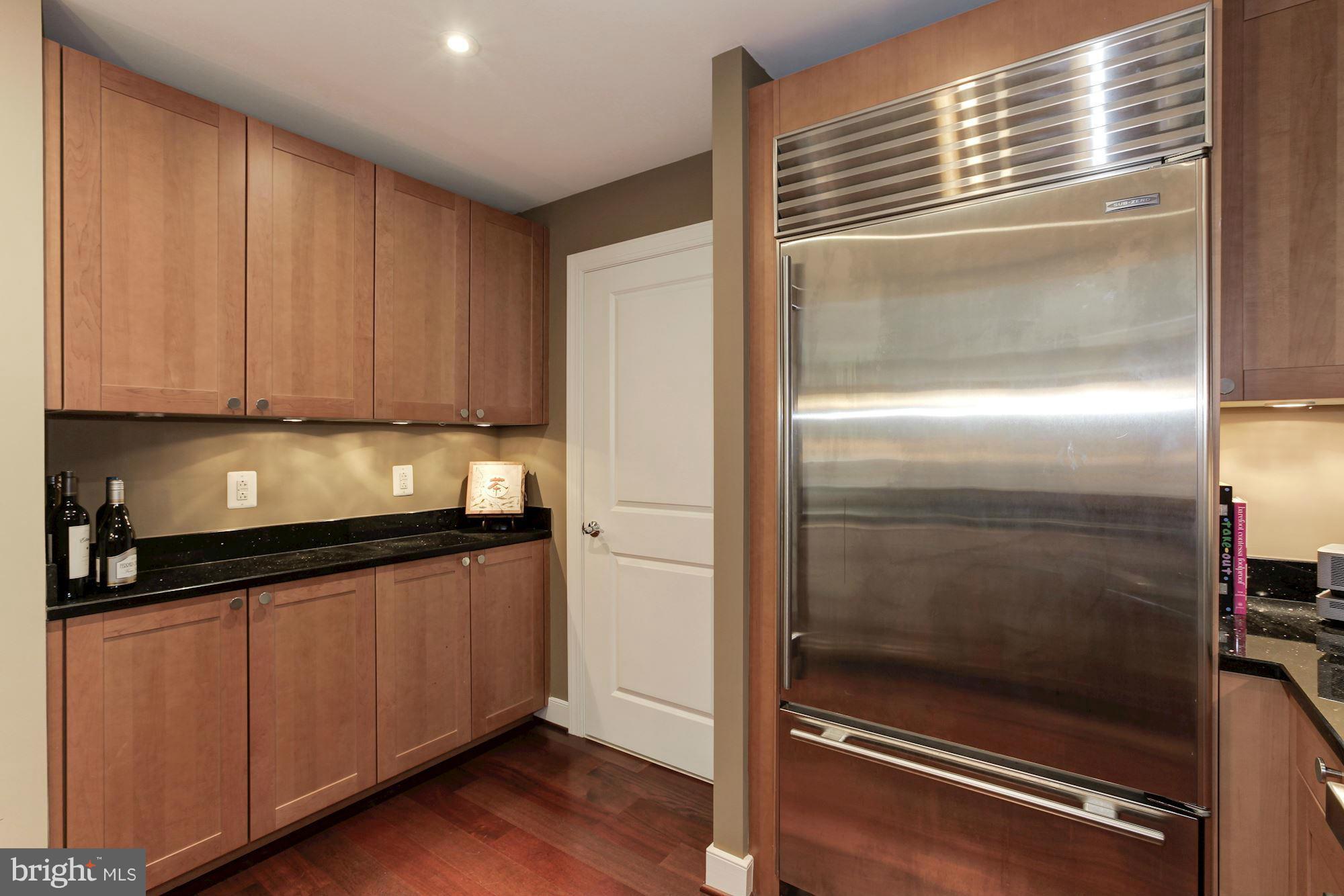 2425 L Street Northwest, Unit 412 Washington, DC 20037 - Photo 10 of 28 a kitchen with granite countertop a refrigerator and cabinets