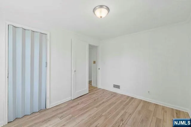 a view of a room with wooden floor and white walls
