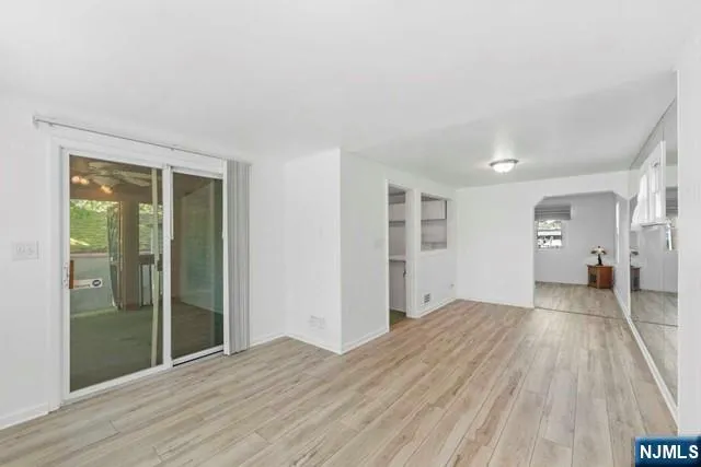 a view of empty room with wooden floor and closet