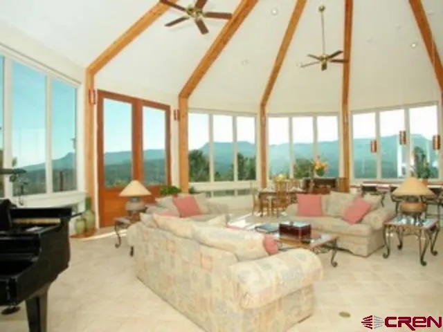 a living room with furniture and floor to ceiling windows