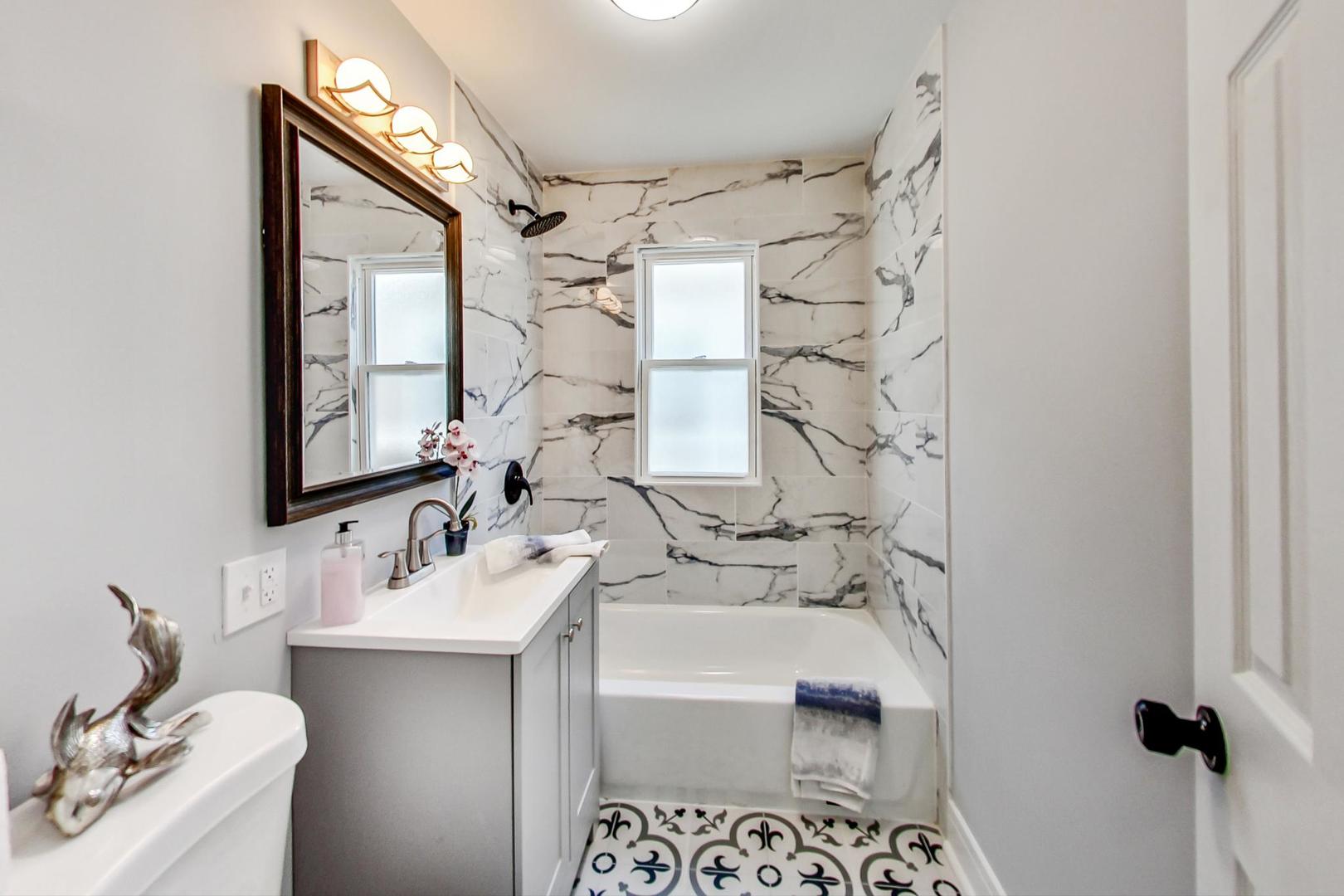 7640 West 63rd Place Summit, IL 60501 - Photo 11 of 29 a bathroom with a sink mirror and a shower