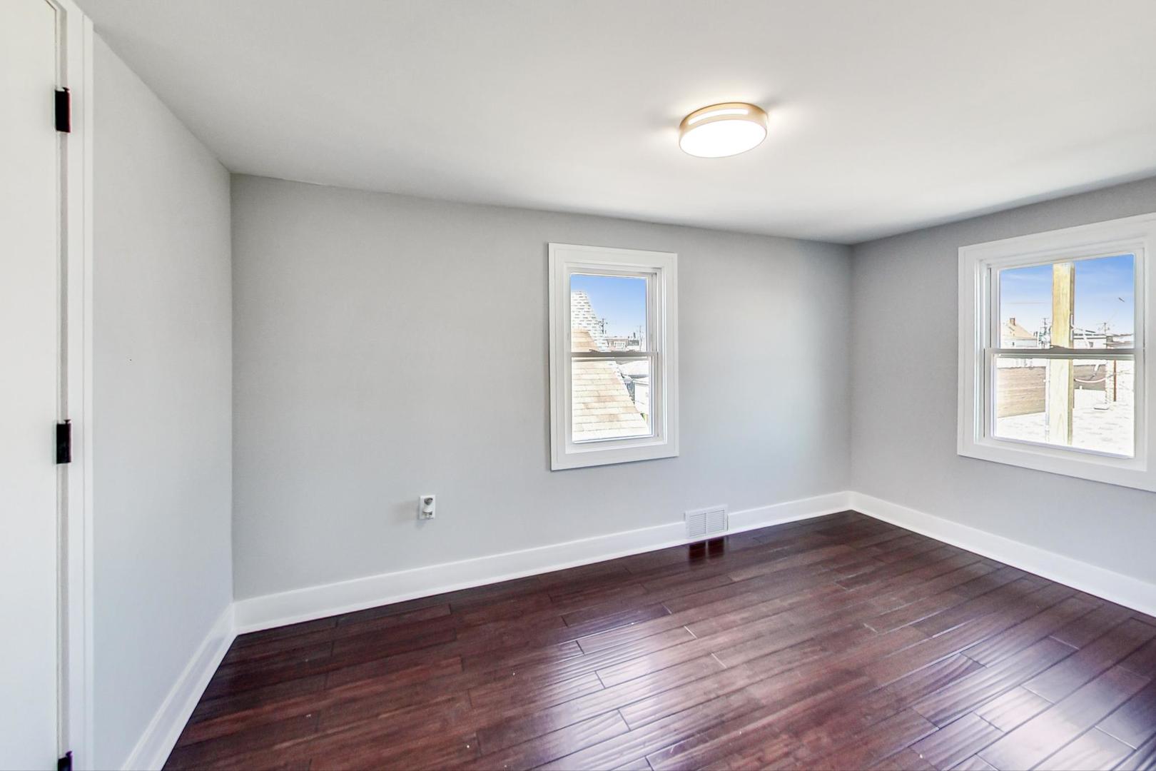 7640 West 63rd Place Summit, IL 60501 - Photo 22 of 29 an empty room with wooden floor and windows