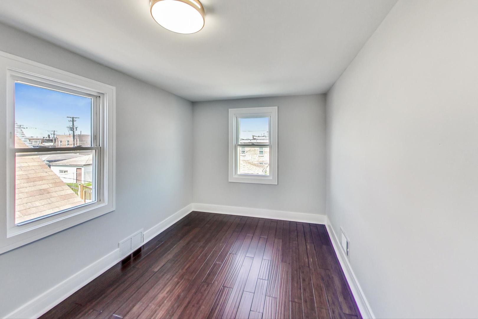 7640 West 63rd Place Summit, IL 60501 - Photo 23 of 29 an empty room with wooden floor and windows