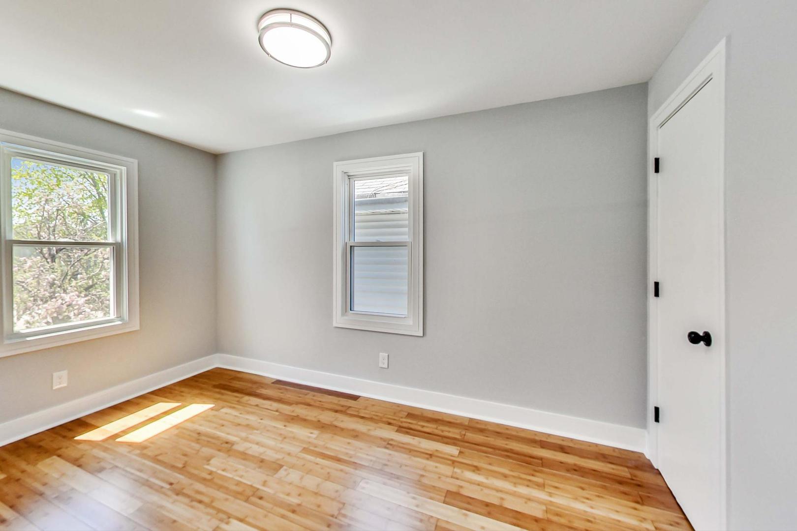 7640 West 63rd Place Summit, IL 60501 - Photo 9 of 29 an empty room with wooden floor and windows