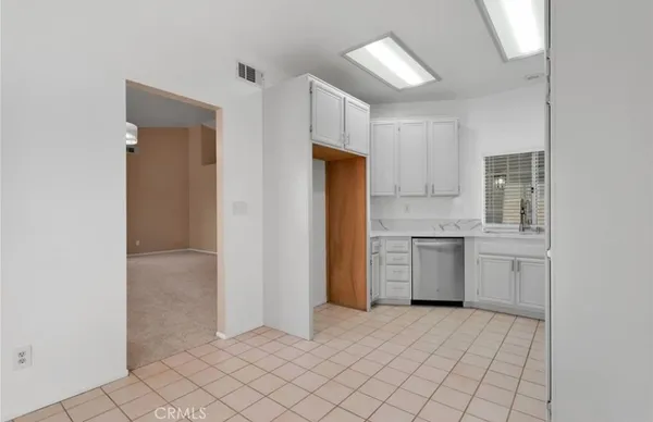 a kitchen with a refrigerator sink and cabinets