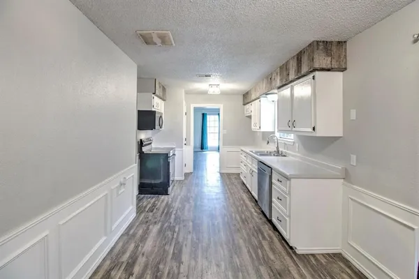a kitchen with a sink and wooden floor