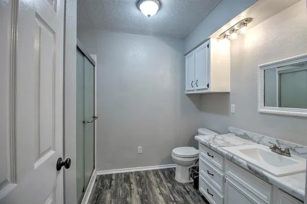 a bathroom with a granite countertop toilet and a sink