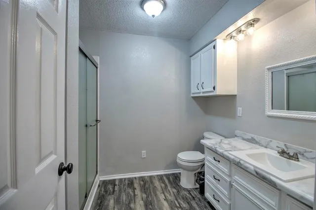 a bathroom with a granite countertop toilet and a sink