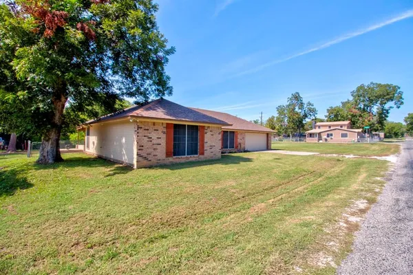 a front view of house with yard and trees