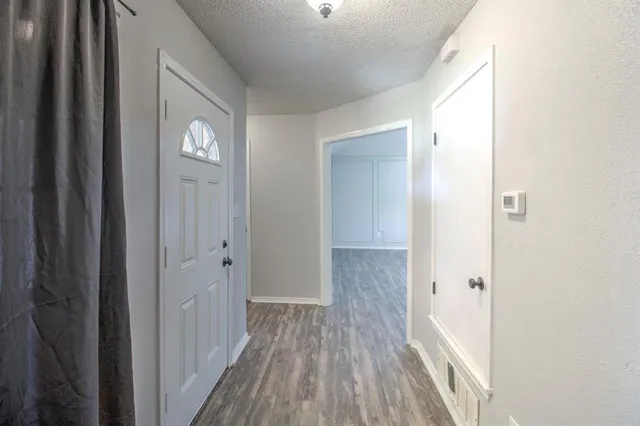 a view of a hallway with wooden floor