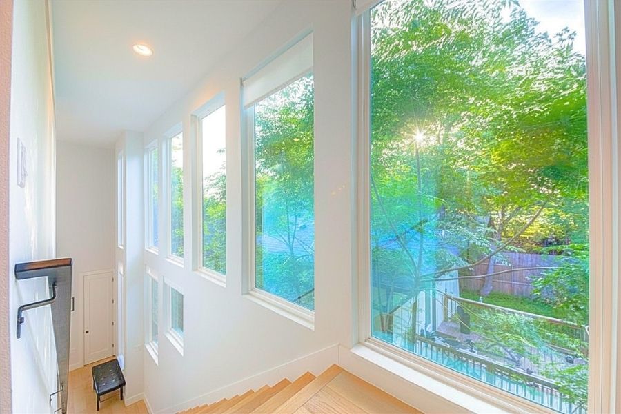916 East 50th Street, Unit 1 Austin, TX 78751 - Photo 12 of 36 The wall of oversized windows look out to the leafy neighborhood as you walk upstairs to 3 of 4 bedrooms in the home.