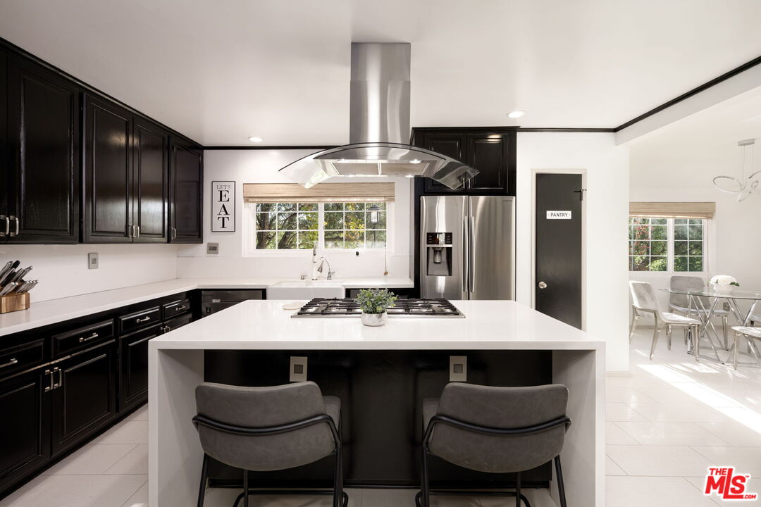 25021 Jim Bridger Road Hidden Hills, CA 91302 - Photo 14 of 30 a kitchen with a dining table and chairs