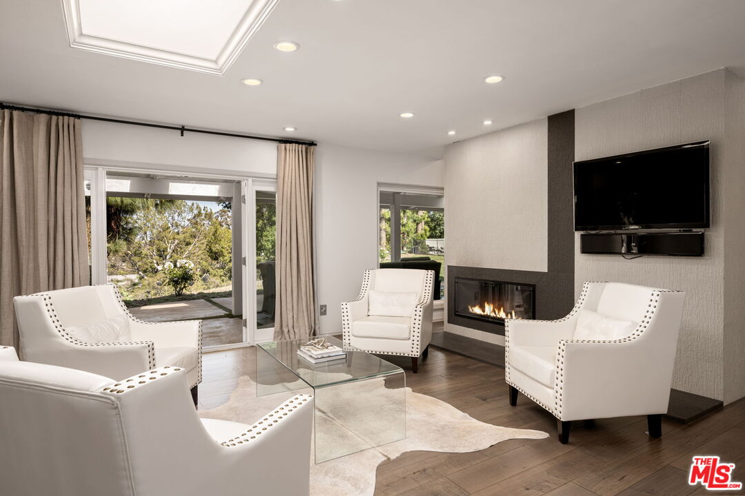 25021 Jim Bridger Road Hidden Hills, CA 91302 - Photo 17 of 30 a living room with furniture a flat screen tv and a large window