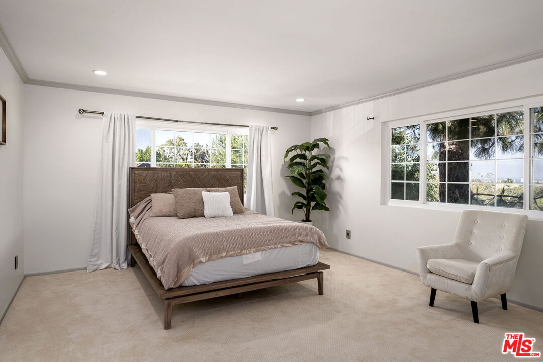 25021 Jim Bridger Road Hidden Hills, CA 91302 - Photo 19 of 30 a spacious bedroom with a bed and a couch