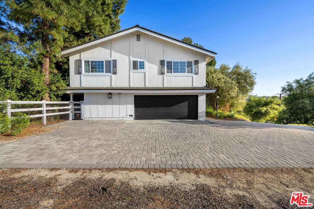 25021 Jim Bridger Road Hidden Hills, CA 91302 - Photo 28 of 30 a front view of a house with a yard and garage