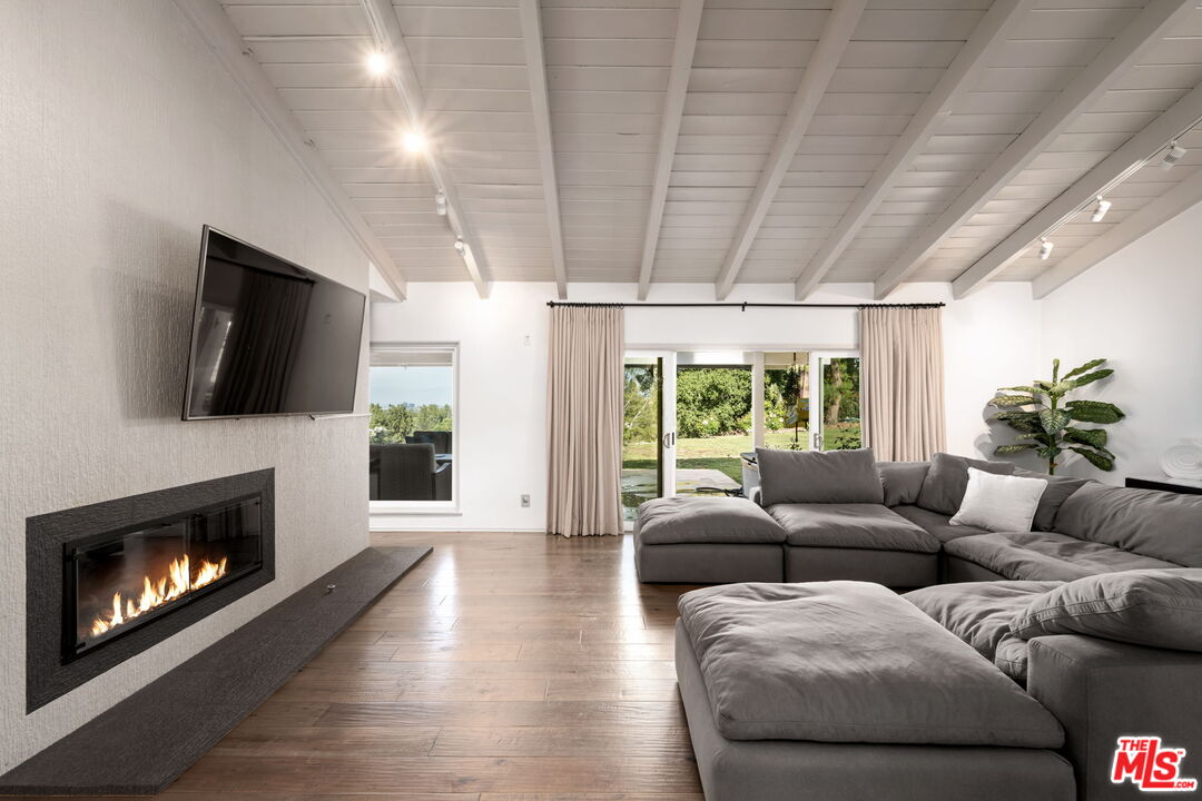 25021 Jim Bridger Road Hidden Hills, CA 91302 - Photo 4 of 30 a living room with furniture a flat screen tv and a fireplace