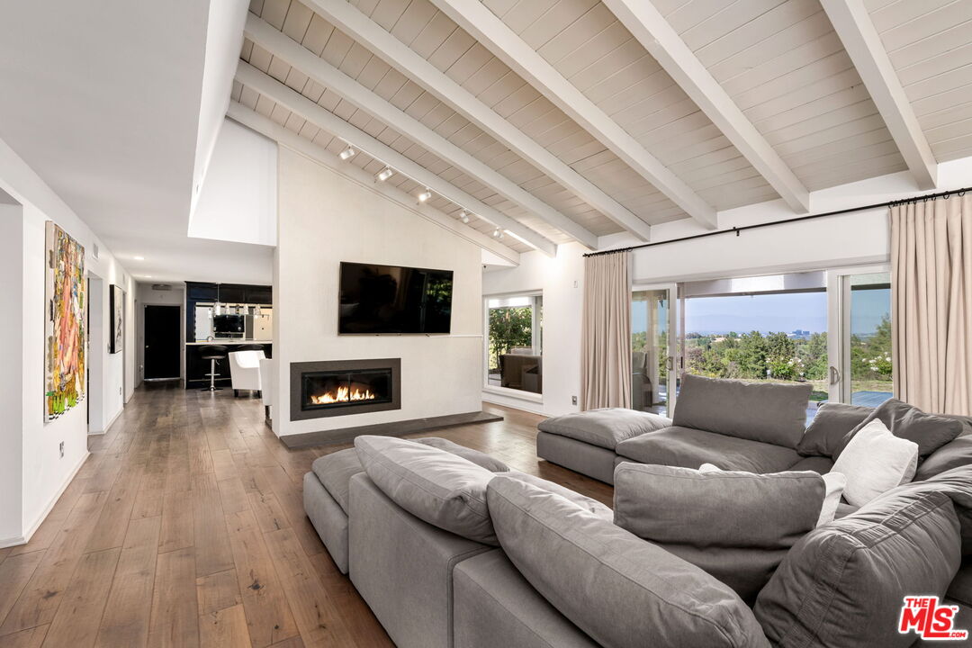 25021 Jim Bridger Road Hidden Hills, CA 91302 - Photo 5 of 30 a living room with fireplace furniture and a flat screen tv
