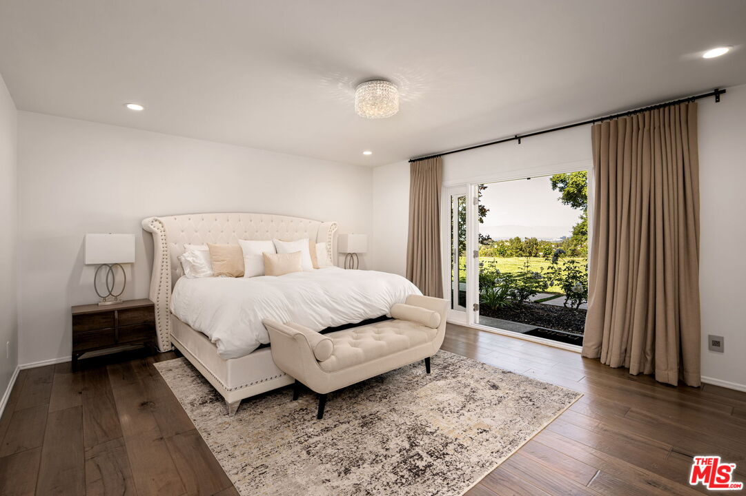 25021 Jim Bridger Road Hidden Hills, CA 91302 - Photo 6 of 30 a bedroom with a bed and wooden floor