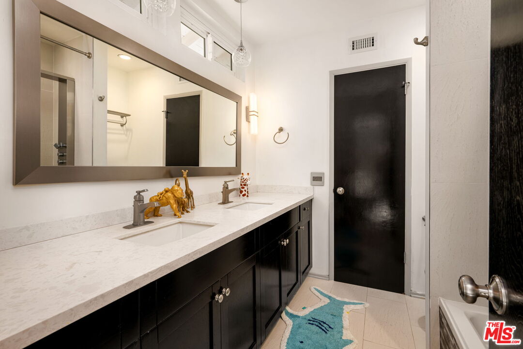25021 Jim Bridger Road Hidden Hills, CA 91302 - Photo 10 of 30 a bathroom with a sink double vanity and a mirror