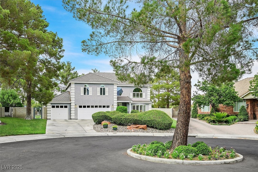 Traditional-style home with driveway, a garage, and a tiled roof