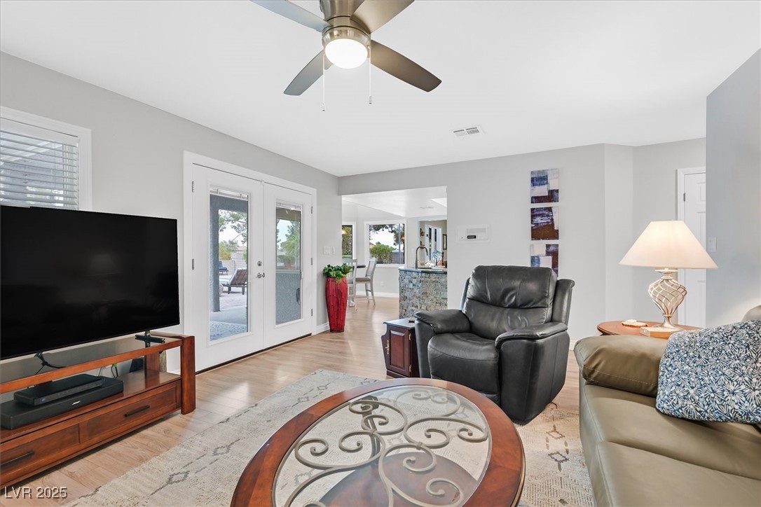 18 Hummingbird Circle Henderson, NV 89014 - Photo 11 of 39 Living room featuring french doors, light wood-style floors, and ceiling fan