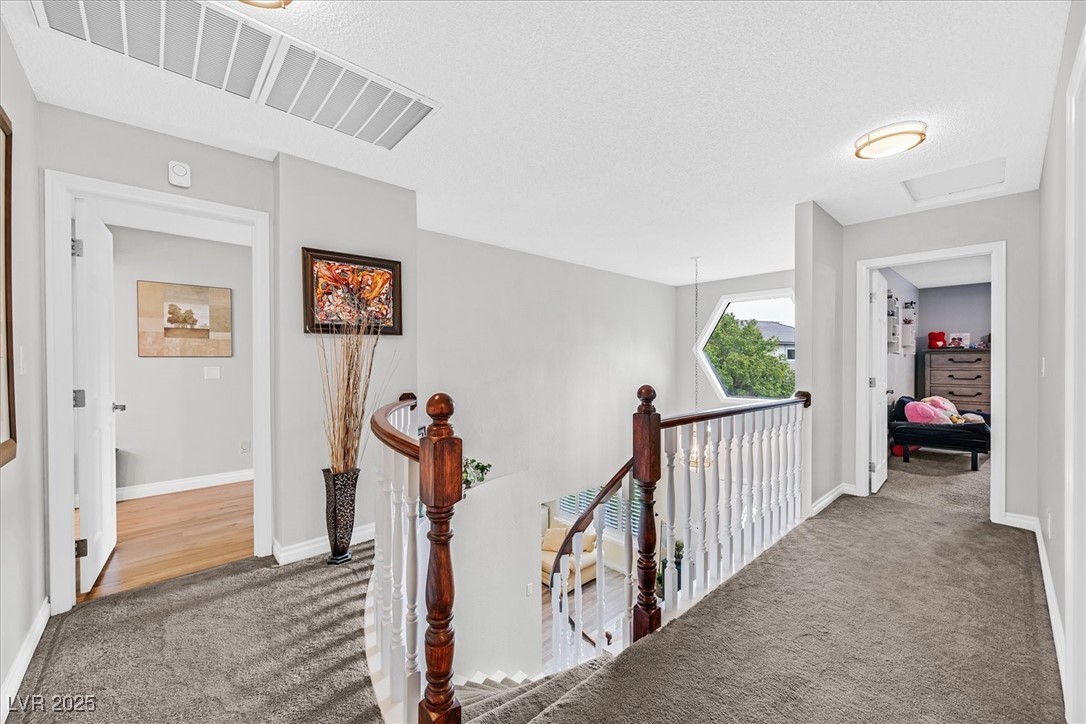 18 Hummingbird Circle Henderson, NV 89014 - Photo 17 of 39 Hallway with carpet, an upstairs landing, a textured ceiling, and attic access
