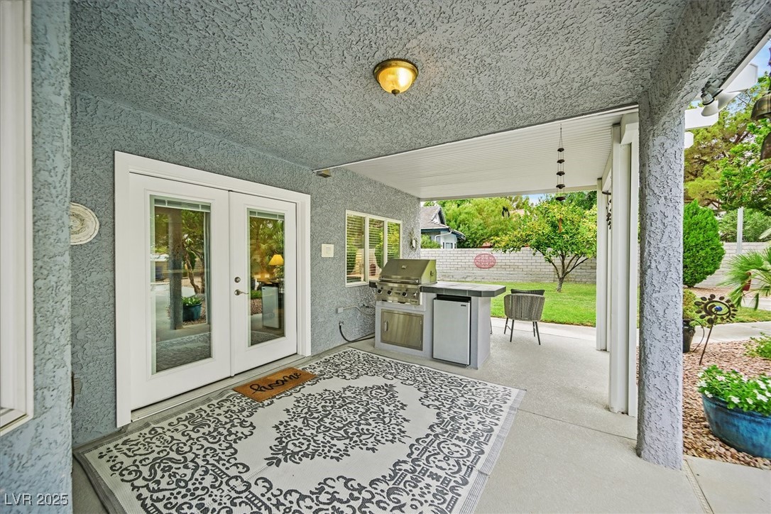 18 Hummingbird Circle Henderson, NV 89014 - Photo 37 of 39 Fenced backyard with french doors, a patio area, and exterior kitchen