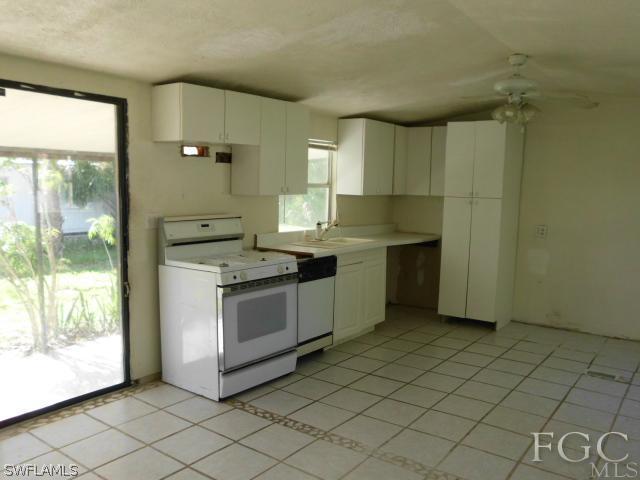 7491 Pinehurst Road Bokeelia, FL 33922 - Photo 5 of 7 a kitchen with stainless steel appliances granite countertop a stove a sink and a refrigerator