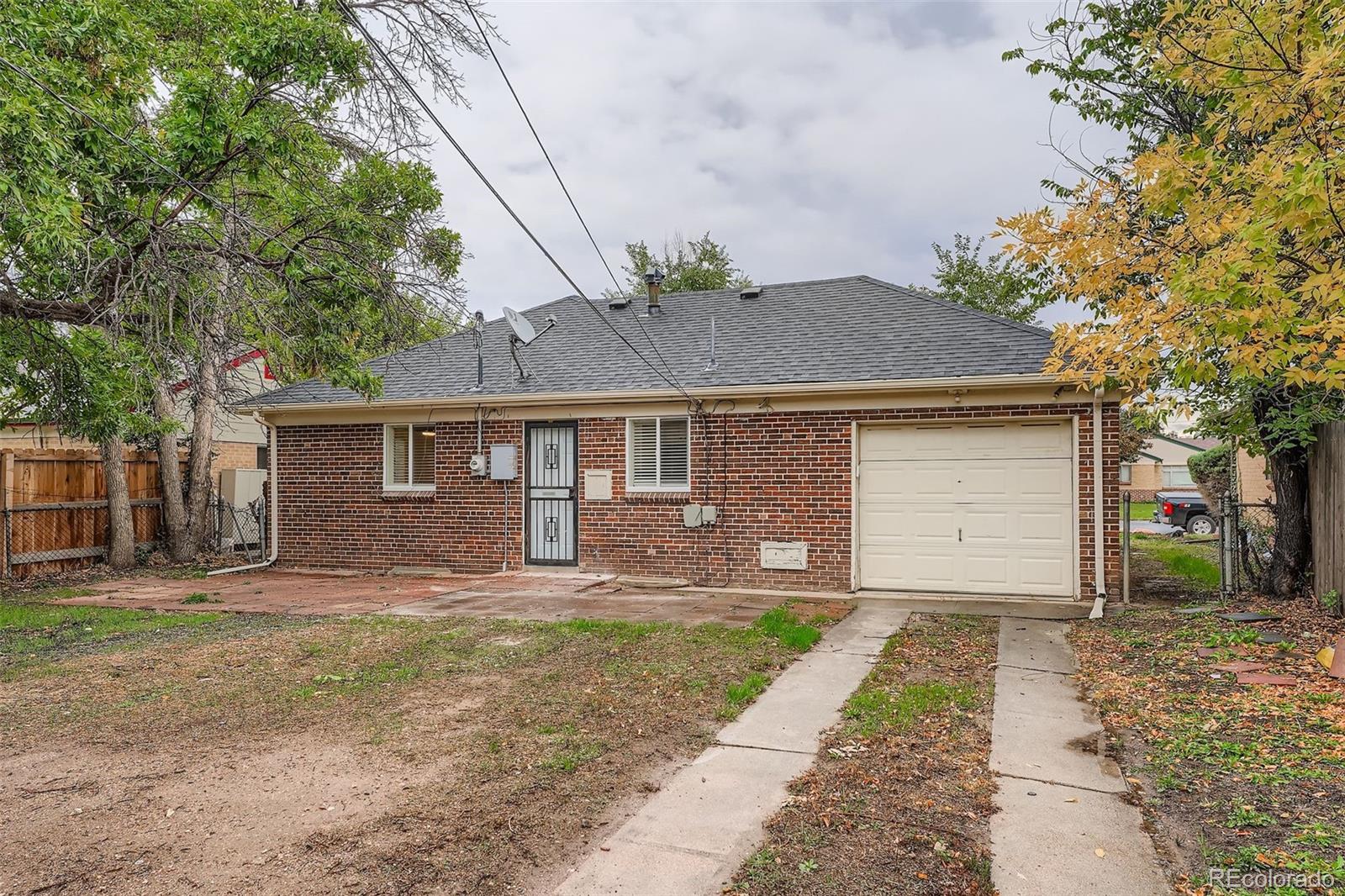 2985 Ivanhoe Street Denver, CO 80207 - Photo 24 of 25 a front view of a house with a yard and garage