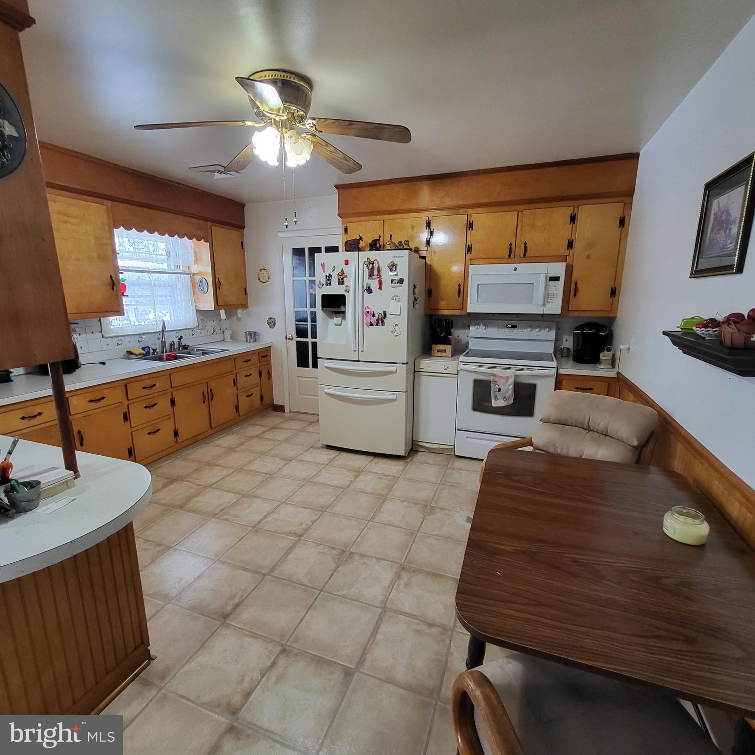2189 Judith Road Hartly, DE 19953 - Photo 10 of 26 a large white kitchen with a stove a sink dishwasher and a fireplace with wooden floor