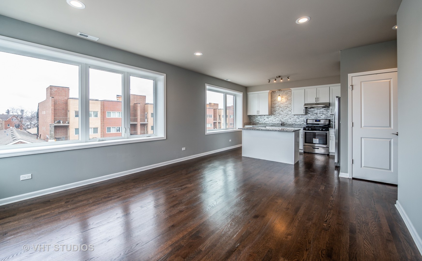 2606 South Halsted Street, Unit 2N Chicago, IL 60608 - Photo 2 of 10 a open kitchen with stainless steel appliances granite countertop a stove top oven a sink and a large window