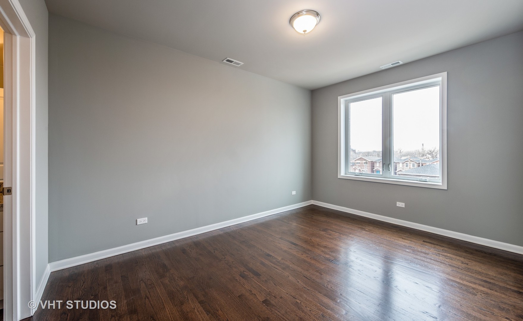 2606 South Halsted Street, Unit 2N Chicago, IL 60608 - Photo 7 of 10 an empty room with wooden floor and windows