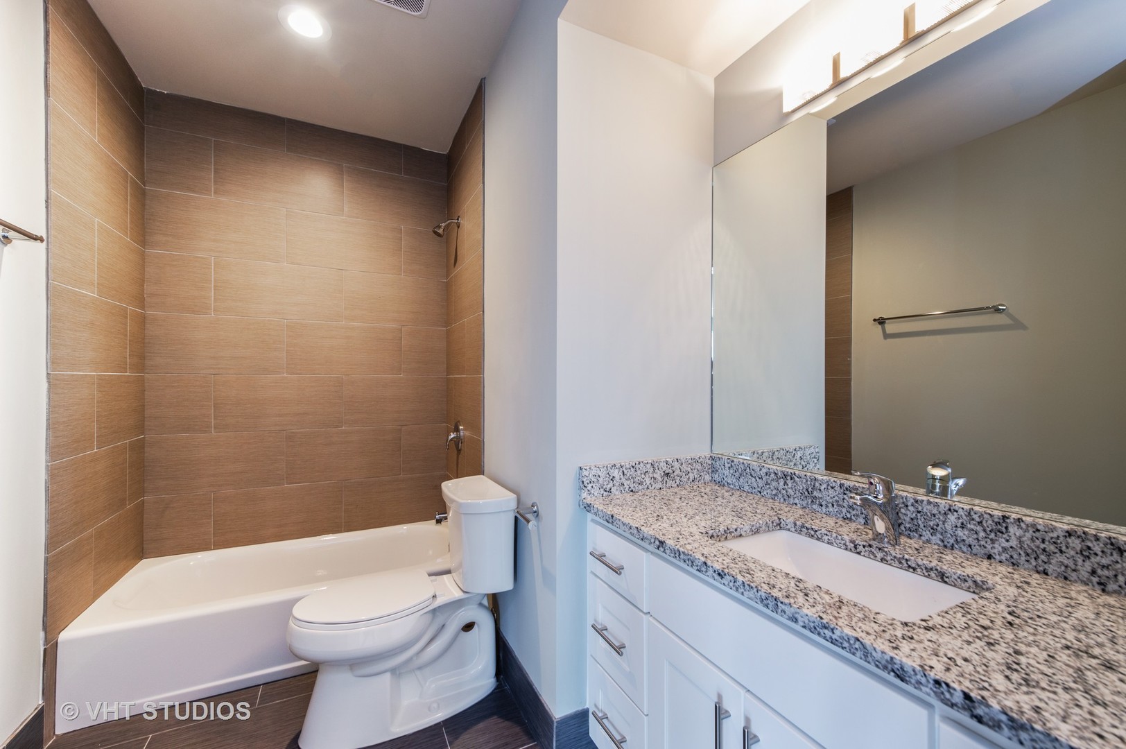 2606 South Halsted Street, Unit 2N Chicago, IL 60608 - Photo 10 of 10 a bathroom with a granite countertop sink a toilet a mirror and bathtub