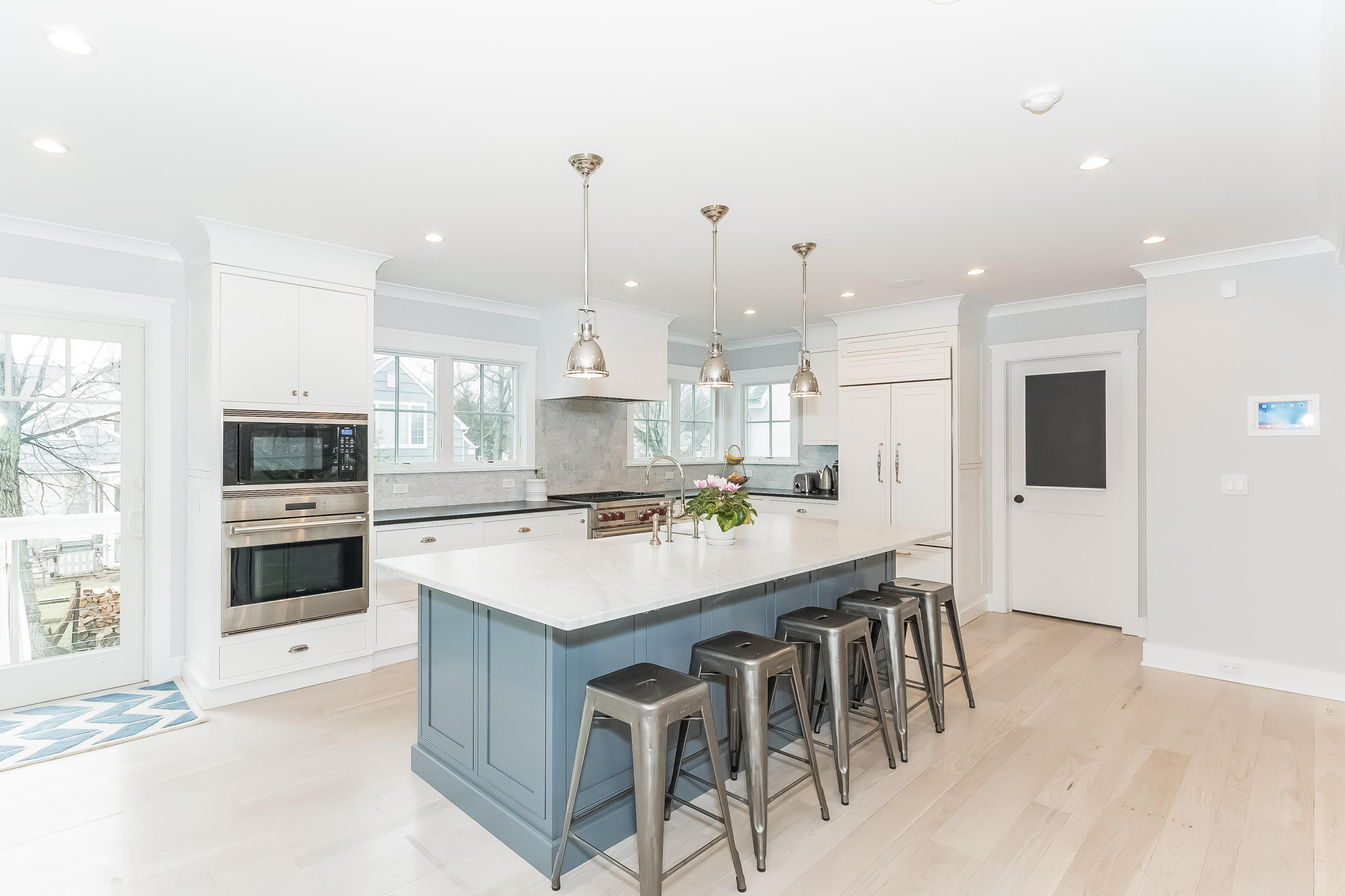 20 Plymouth Road Darien, CT 06820 - Photo 11 of 46 a large kitchen with kitchen island a stove a sink a refrigerator and a dining table with wooden floor