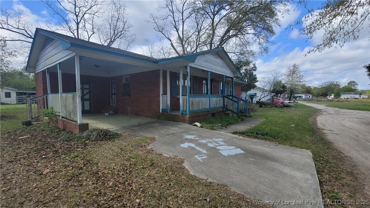 a front view of a house with a yard and trees